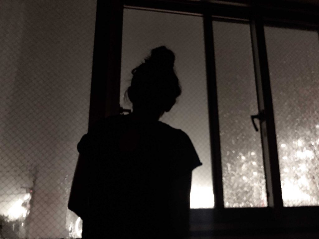 woman watching a storm at night through the window t20 loENxg scaled